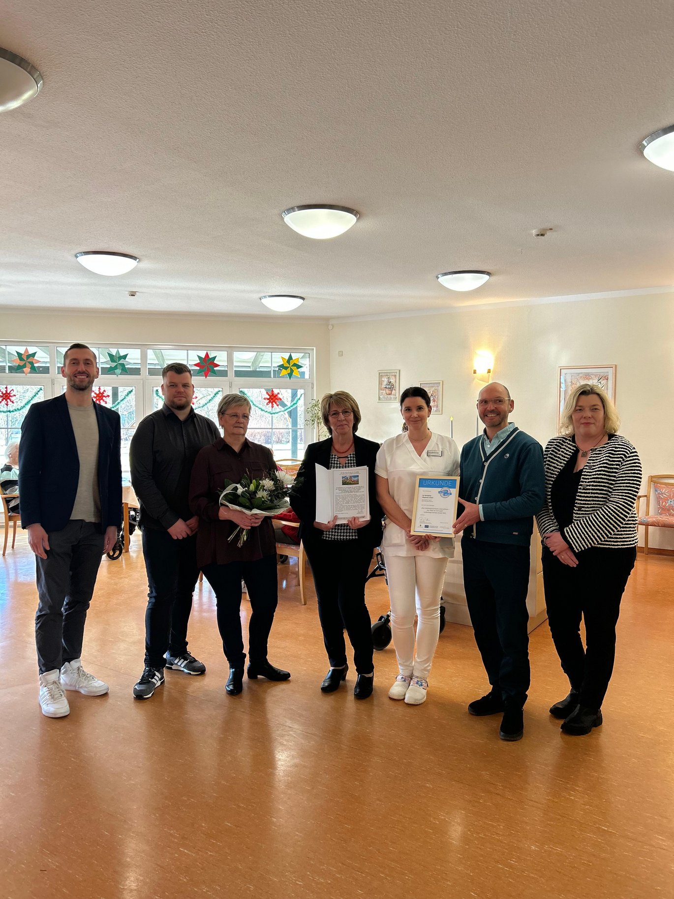 Einige mitarbeitende des Pflegeheimes bekommen das Landessiegel überreicht