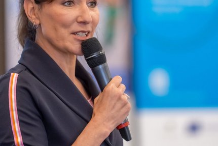 Eine Frau mit einem Mikrofon in der Hand.