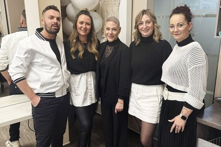 Eine Gruppe Menschen stehen in einem Friseursalon.