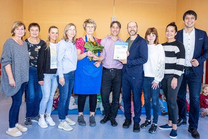 Eine Gruppe Menschen bekommen eine Urkunde überreicht