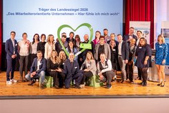 Preisträger des Landessiegels 2026 „Das mitarbeiterorientierte Unternehmen – Hier fühle ich mich wohl“ präsentieren sich gemeinsam auf der Bühne – Auszeichnung für Arbeitgeberattraktivität in Sachsen‑Anhalt.