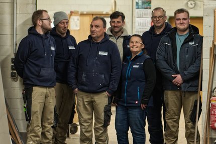 Eine Gruppe von Menschen stehen in einer Werkhalle
