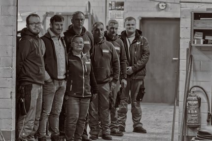 Eine Gruppe von Menschen stehe in einer Werkhalle