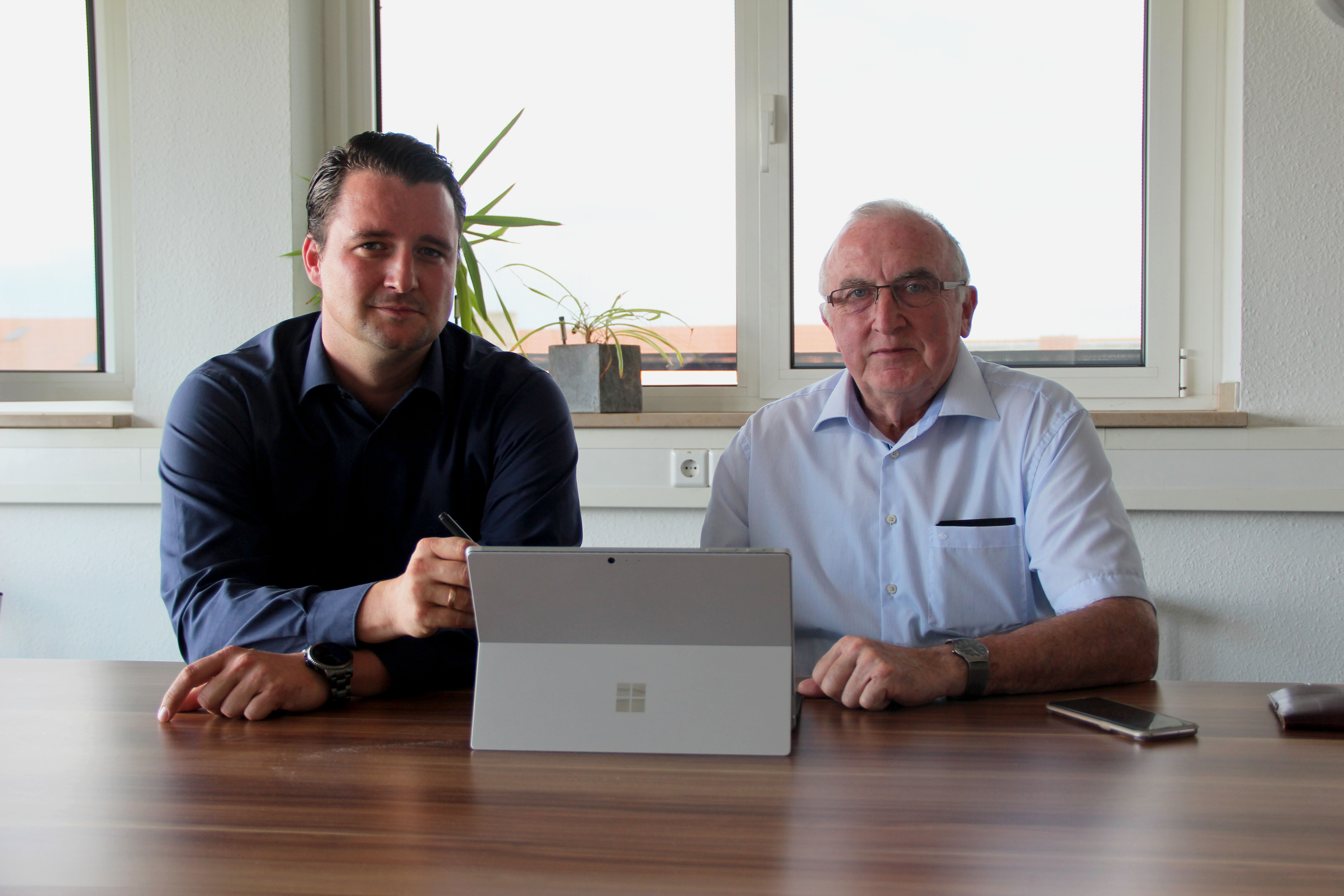 Unsere Digitalisierungsberater Felix Malter (links) und Siegfried Simolke (rechts) sitzen am Tisch an einem Laptop(Foto: Fachkraft im Fokus).