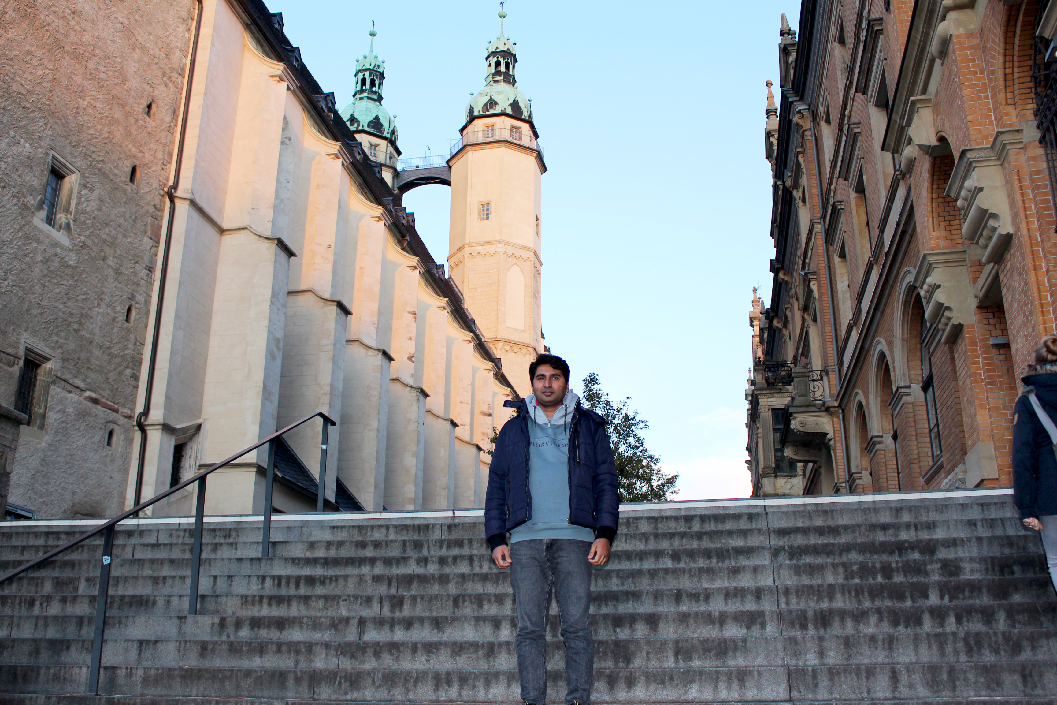 Ein Mann steht auf einer Treppe, hinter ihm eine Kirche.