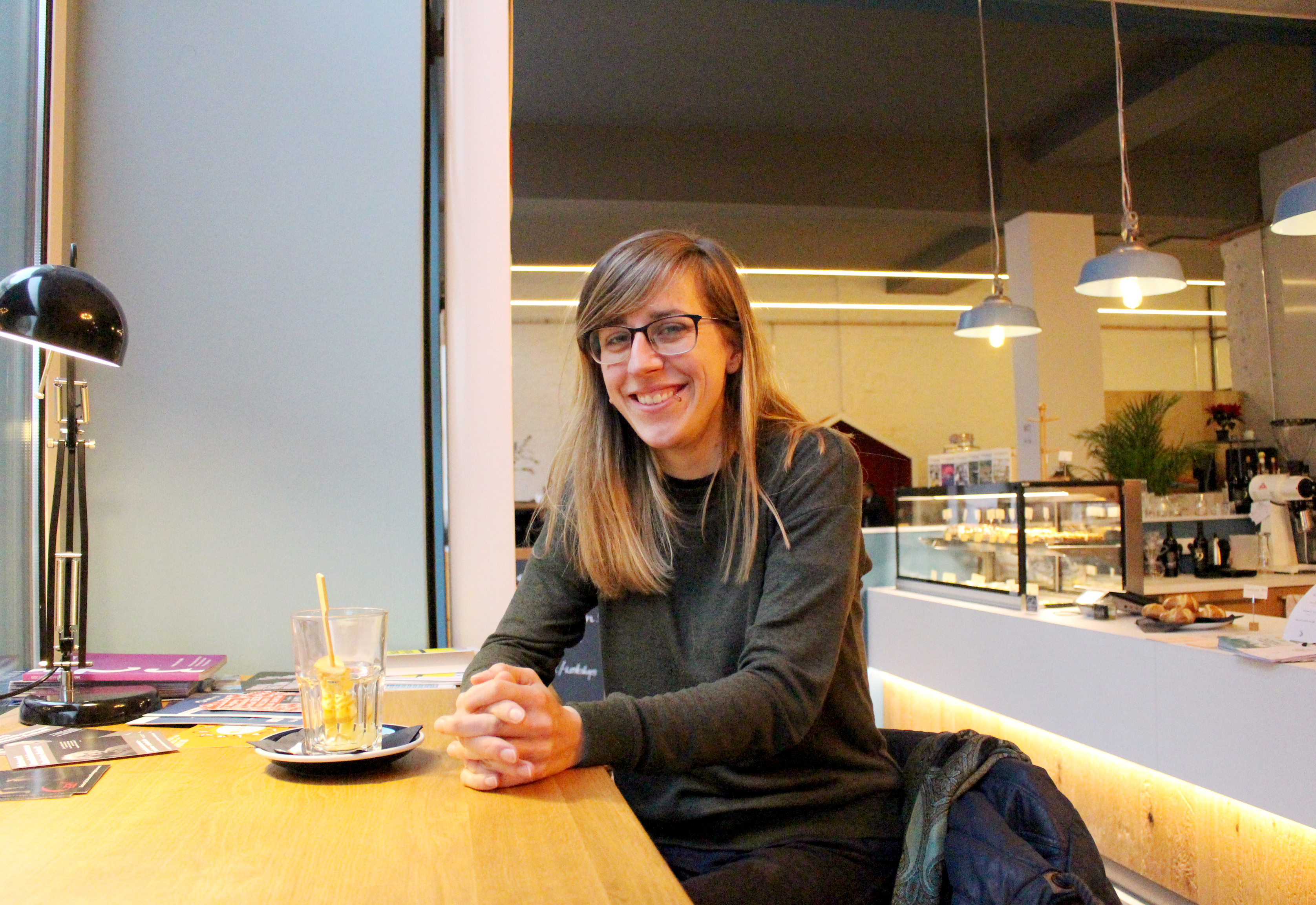 Eine Frau sitzt an einem Tresen in einem Café.