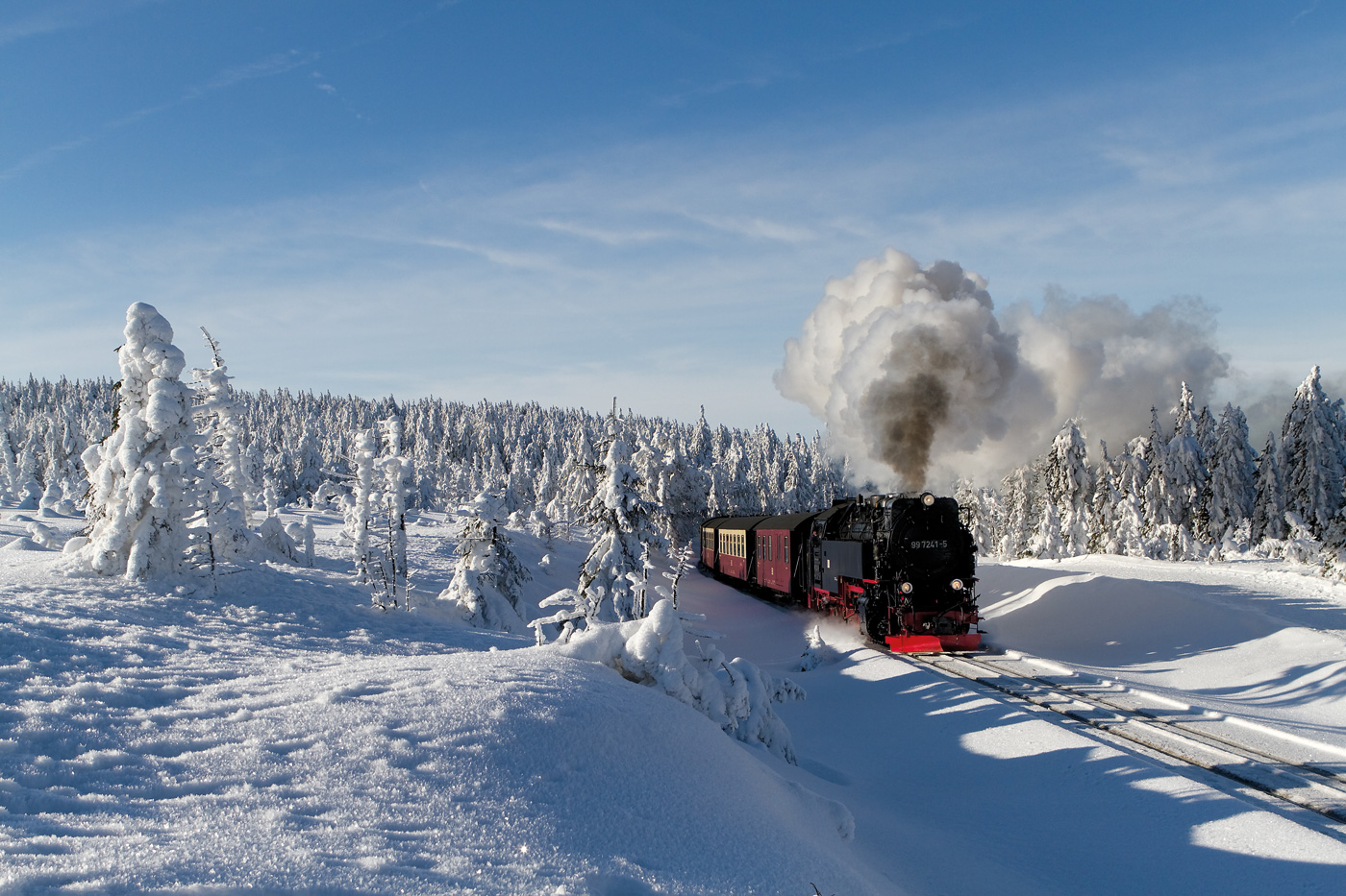 Die Brockenbahn fährt durch eine winterliche Lsnadschaft